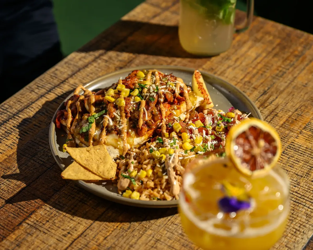 Plated Mexican main with cocktail at El Mexicano Kitchen & Bar